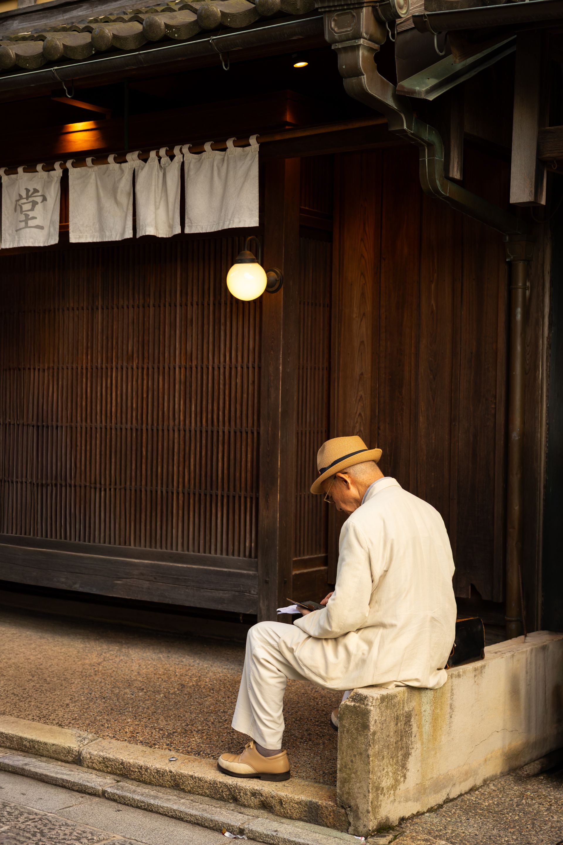 夕暮れの蔵の前に佇む八代目蔵元・杜氏