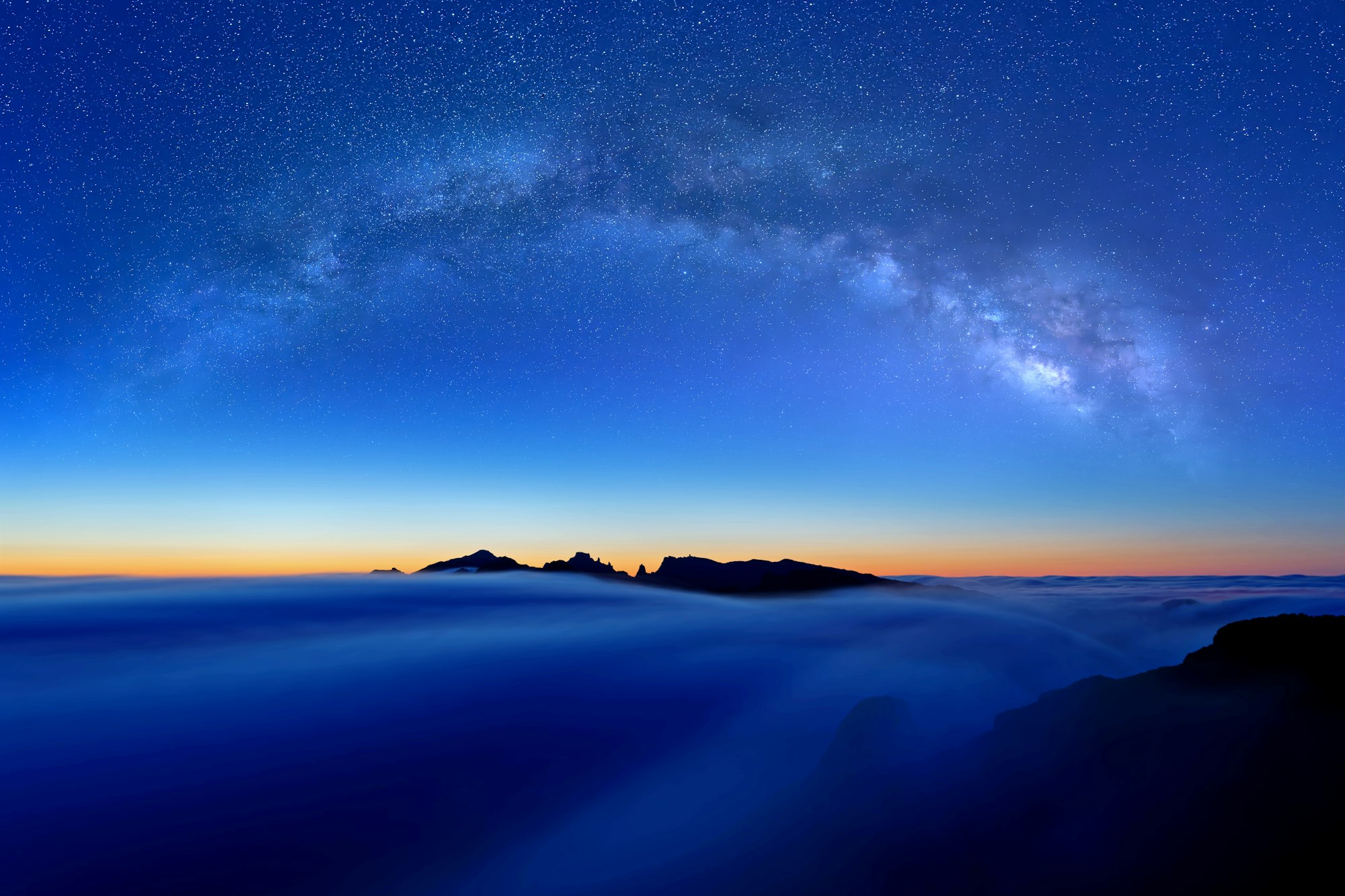 天の川がアーチを描く、雲海の上の星空